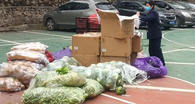 University authorities and volunteers ready to deliver fruits and vegetables to students on lockdown at the Hubei Province.