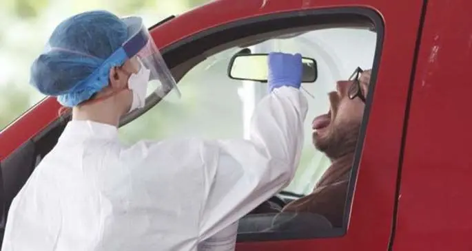 A medical worker takes a swab sample at a COVID-19 drive-thru testing site in Washington D.C., the United States, May 19, 2020. (Photo by Ting Shen/Xinhua)