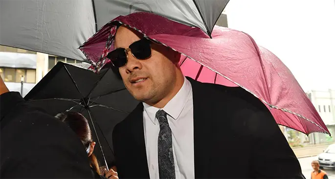 Jarryd Hayne walking into court shielded by umbrellas before he was jailed. Photo: News Corp Australia
