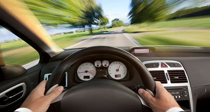 Man in suit driving a car from vehicle interior