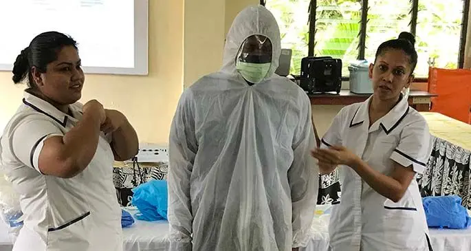 Nurse Ashlyn Datt demonstrates the right way to put on a Personal Protective Suit to training participant, Watisoni Vereivalu, of the National Fire Authority at St John’s Ambulance training room in Suva on April 1, 2020.Photo: Inoke Rabonu