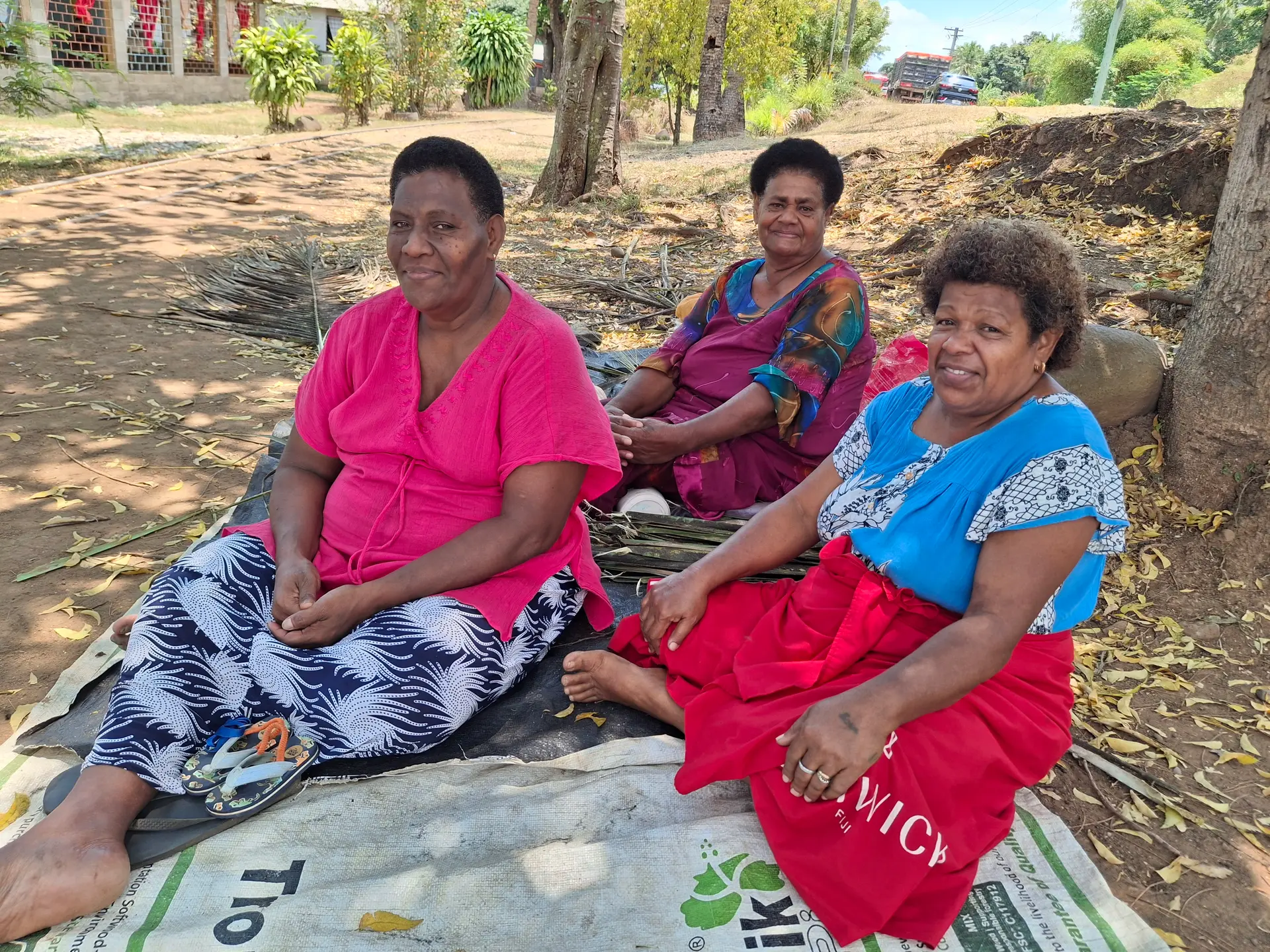 Atelini Naqiri, Sereana Rita and Vaciseva Galo pointing to the breadfruit trees in front of their homes at Matawalu Village in Lautoka.  