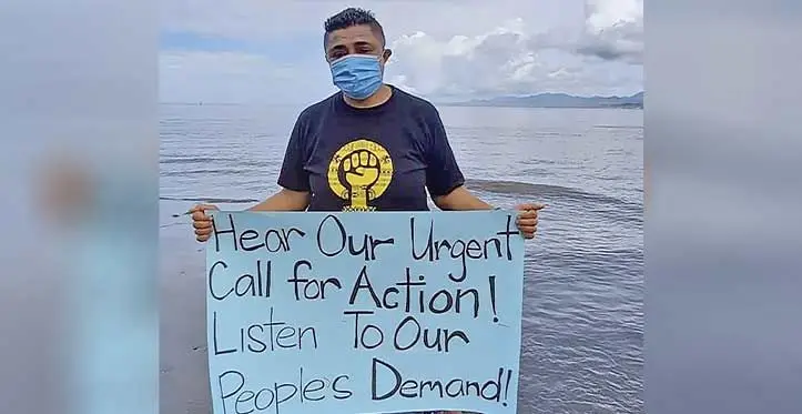 A climate change advocate with a placard calling on leaders for urgent climate action.