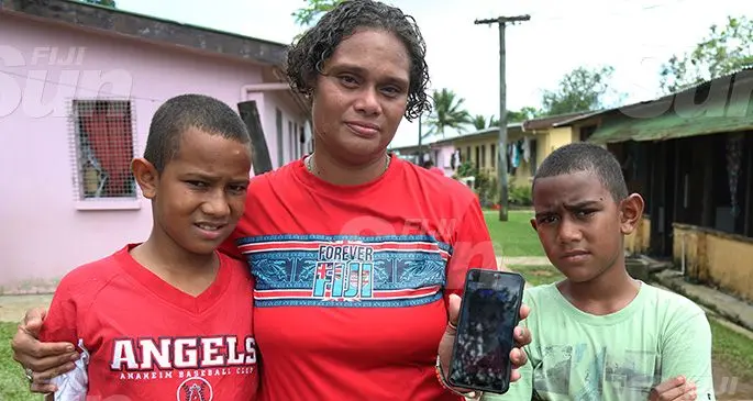 Peter and Ian Mataika with their Mum Asena Tutu holding a picture of her daughter Makereta Mataika. Photo: Kelera Sovasiga