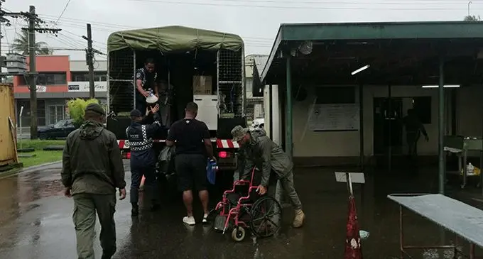 Both Police and RFMF personnel were on hand to help relocate those admitted at the Nausori Health Centre to Vunimono High School, also in Nausori. Photo: Fiji Police Force.