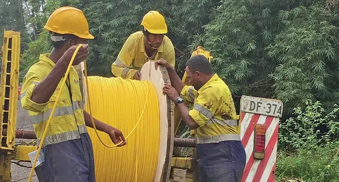 Telecom Fiji staff installing fibre optic cables.