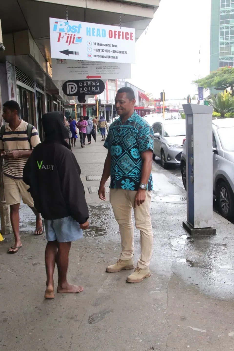 Mataiasi speaking to a shoe shiner.