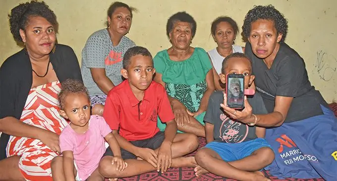 Mere Lewaravu holding the picture of her late father, Mikaele Sarosaro, with family members at Korociri in Nadi. Photo: Mereleki Nai