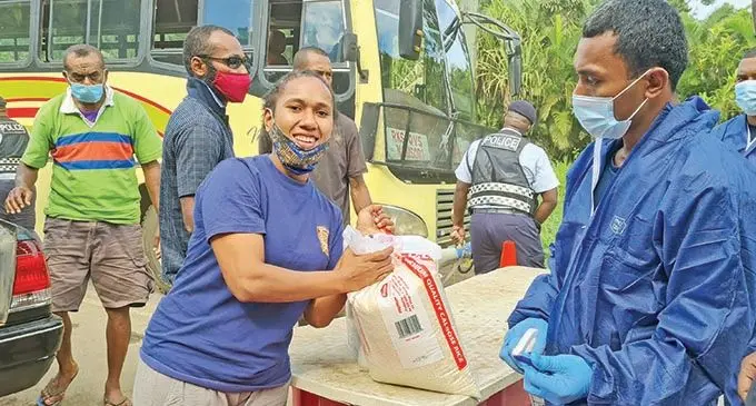 Akisi Soroavoli receives her food rations at the Logani border in Tailevu on June 16, 2021. Photo: Fiji FA Media