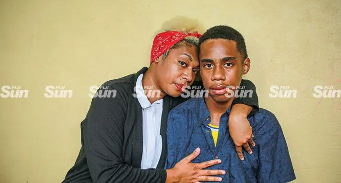 Karalaini Tuitubou on May 26, 2022, comforts her son Kitione Levaci, 14, who was  allegedly assaulted in Kuku, Tailevu.  Photo: Leon Lord