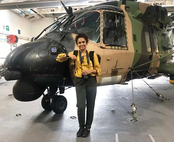 Fiji Sun Digital journalist Jennis Naidu next to a military helicopter onboard the HMAS Adelaide.