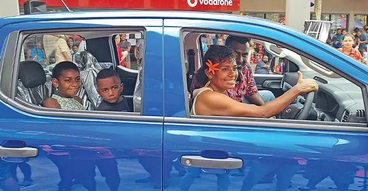 Seini Morovia with her family inside the Ford Ranger that she won.