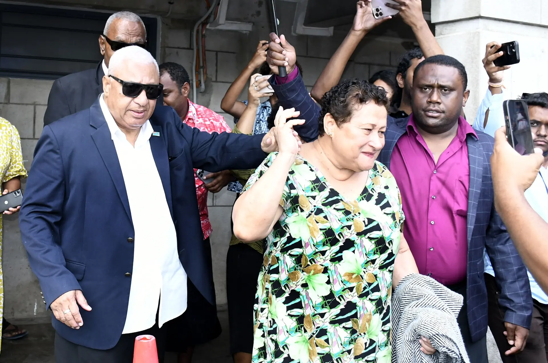 A relieved former Prime Minister Voreqe Bainimarama with his wife, Mary Bainimarama, outside the Suva Courthouse following his sentencing on October 22, 2025.