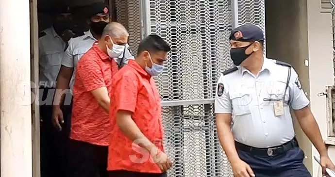 Ashneel Kumar (front) and his father Ajay Kumar are escorted out of the Lautoka Magistrates Court holding cell on October 13, 2021. Photo: Salote Qalubau
