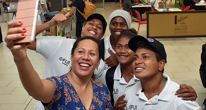 A fan with the Fiji Airways Fijiana 7s reps (left-right) Sereana Nagatalevu, Raijeli Daveua, Tokasa Seniyasi, Lavenia Tinai at Nadi International Airport  on April 24, 2019.  Photo: Waisea Nasokia