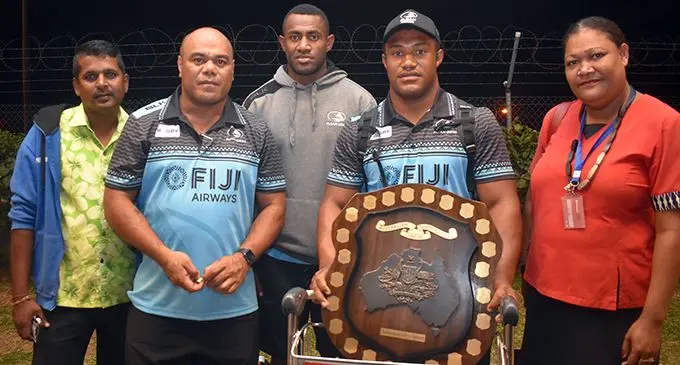 Fiji Airways Fijian Drua coach Senirusi Seruvakula (second from left) and Maikeli Sivo (holding Horan/Little Shield) with fans at Nadi International Airport on September 3, 2019. Photo: Waisea Nasokia