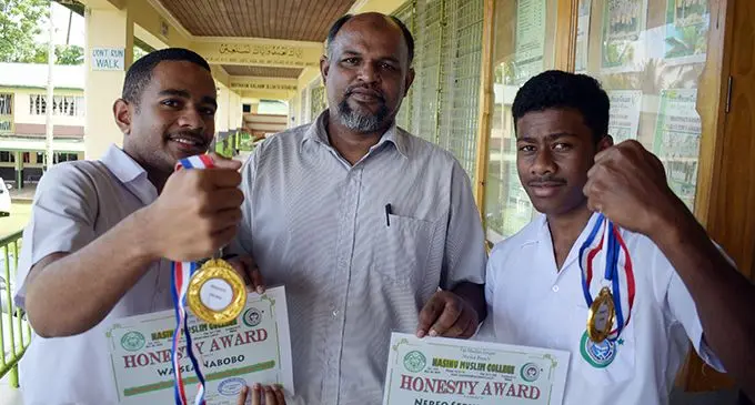 Nasinu Muslim College students Waisea Nabobo (left) and Nereo Seruliwaliwa after receiving their honesty award from Principal Safiq Ahmed on May 23, 2019.  Photo: Ronald  Kumar