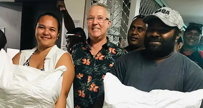 Hilton Fiji Beach Resort and Spa area general manager David Wells with Sabrina Lanyon and Aporosa Odro holding their food packs.