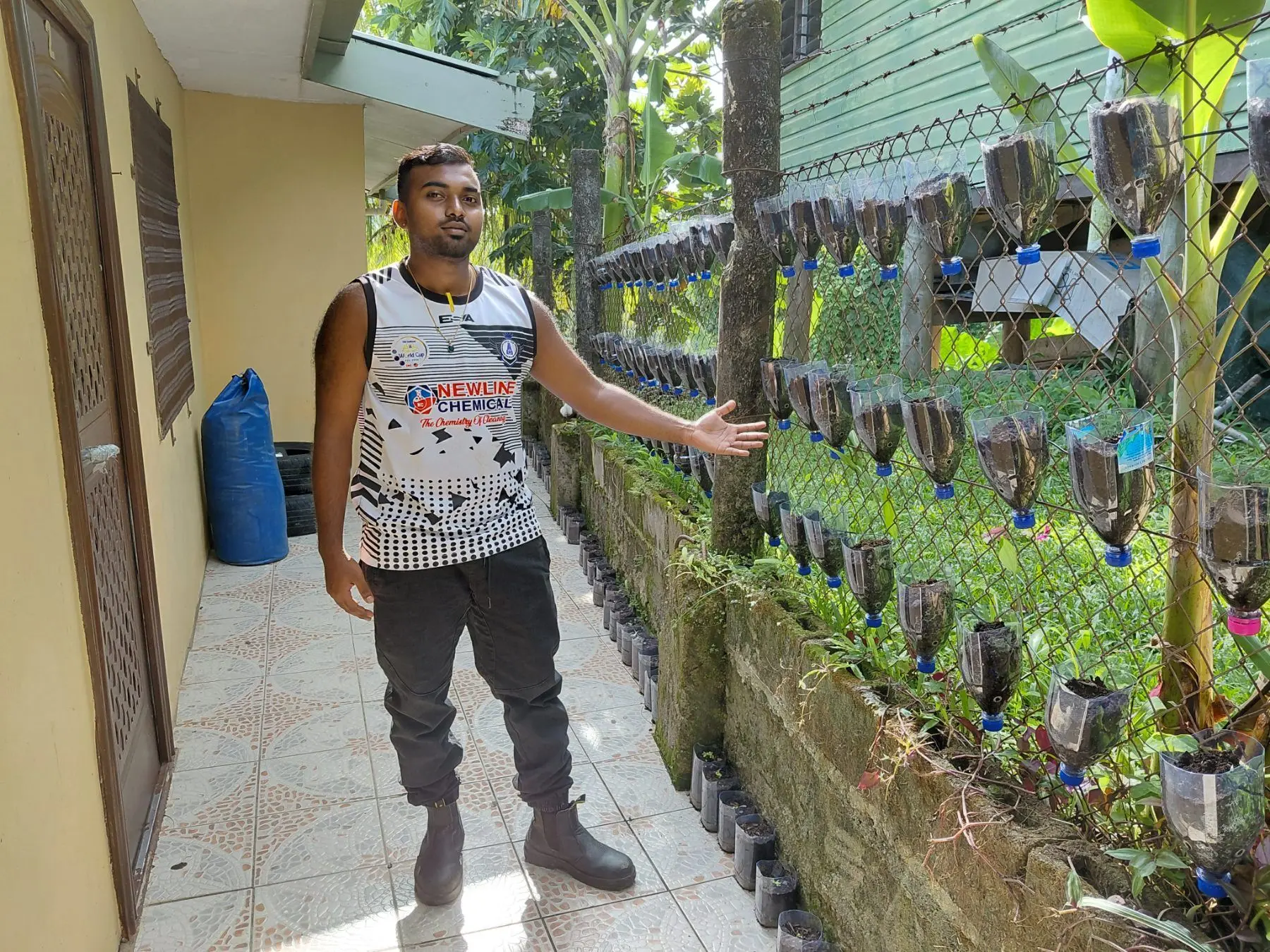 Bhaveekesh Reddy shows his recycled bottle planting system used to grow seedlings at his home-based farm on December 26, 2025.
