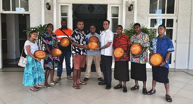 Rainal Sahai (fourth from right, )Executive Chef—Grand Pacific Hotel, receives wooden Tanoa (Fijian Bowl) from Mikaele Korovou fourth from left and Shane Suka (fifth from left )from the Ministry of Forestry and students from the training centre.