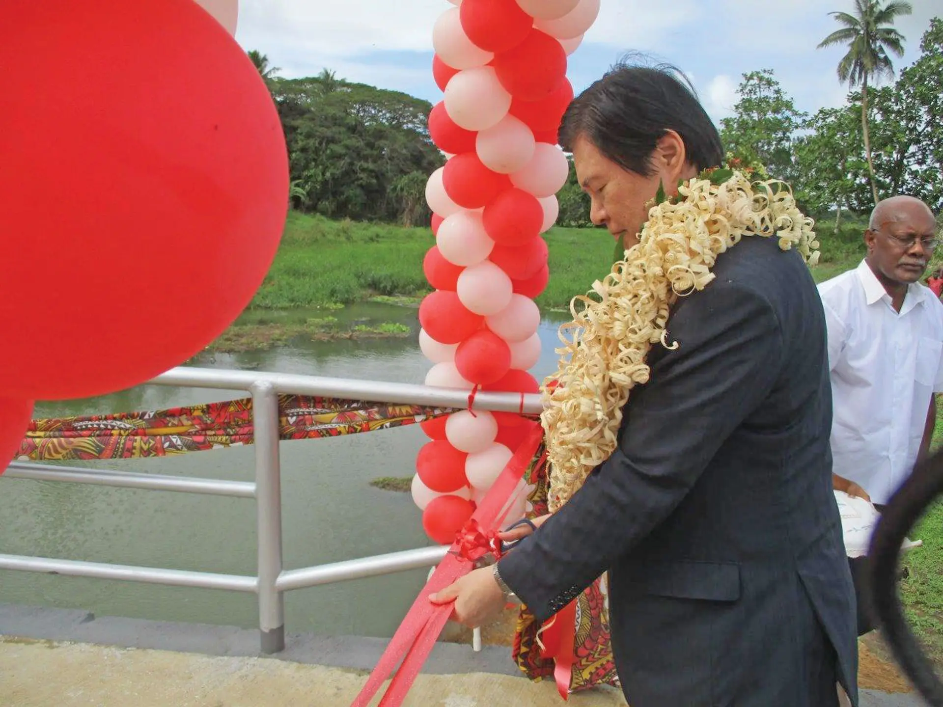 Ambassador of Japan to the Republic of Fiji Masahiro Omura cuts the ribbon during the opening of the Visama Village in Nakelo, Tailevu