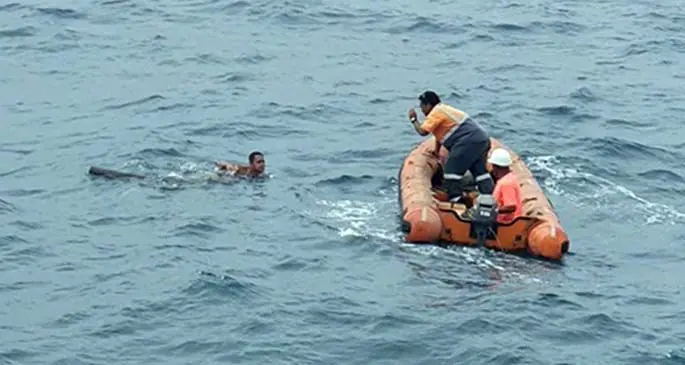 Two crew members of the Interlink Shipping ferry MV Ohana attempt to rescue the man after he jumped off the vessel. Photo: Jitendra Reddy