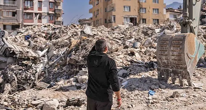 A man stands in front of buildings destroyed by the quake in Antakya, southern Turkey on 20 February. Photo: AFP