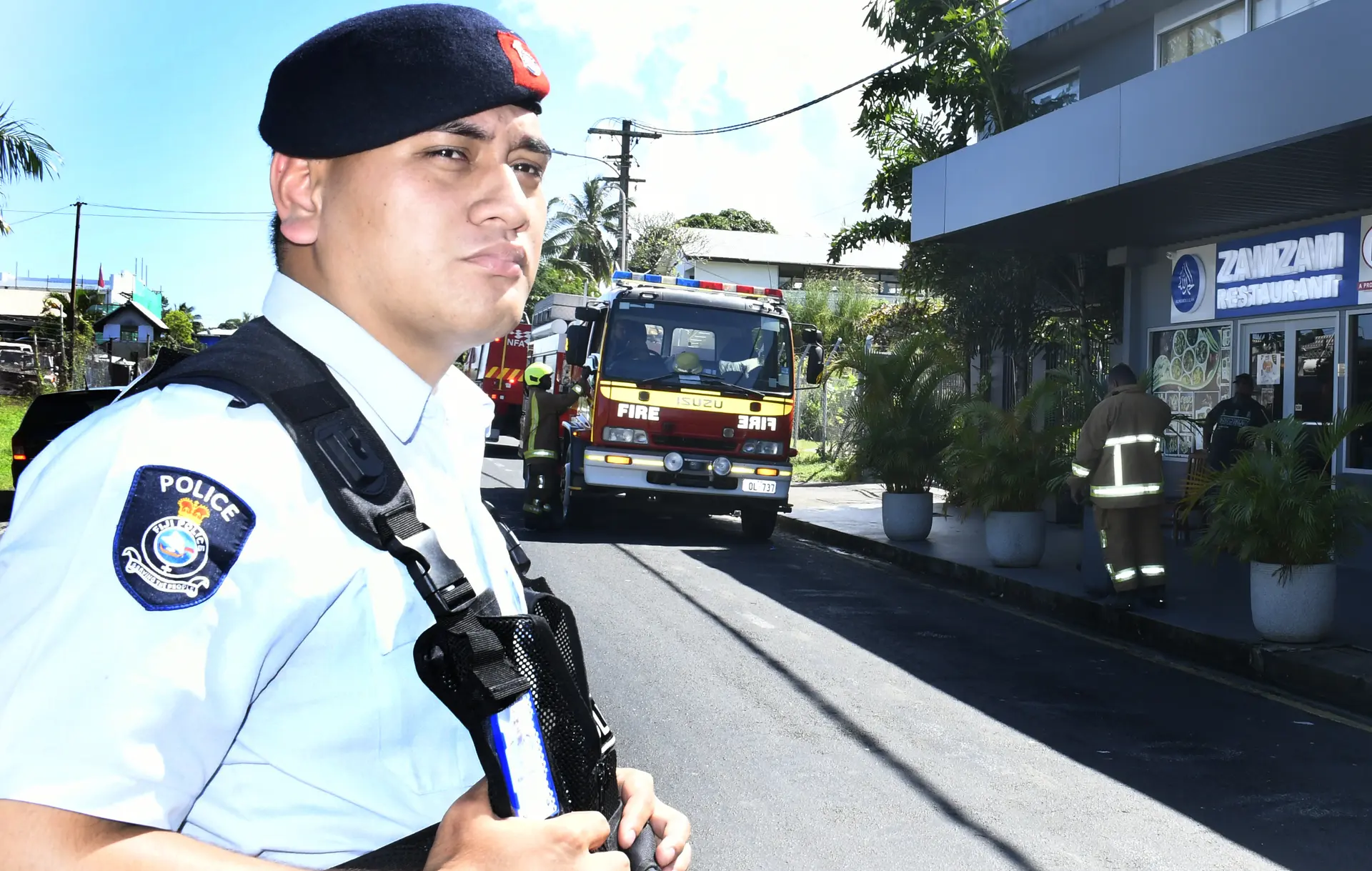 A police officer stands guard in Samabula on May 5, 2026, as the National Fire Authority crew attend to the fire at the popular Zamzam Restaurant. 