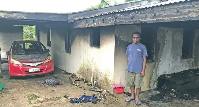 Paula Koroi infront of their home and vehicle on January 28, 2021, that was destroyed in a fire.  Photo: Kelera Sovasiga 