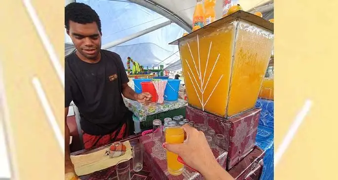 Ilitai Masilaca serves juice to a customer at the Suva Market.