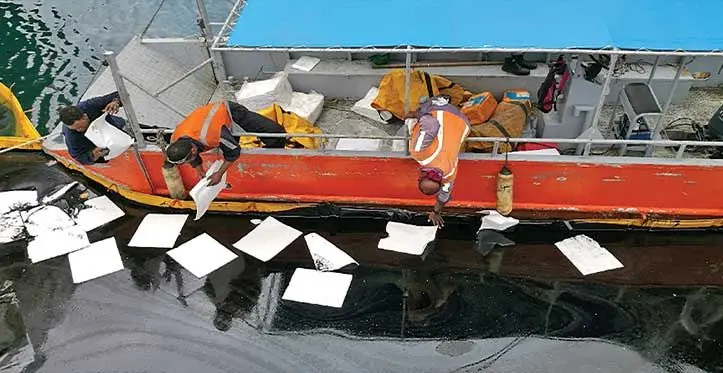 Maritime officers controlling the flow of an oil spill.