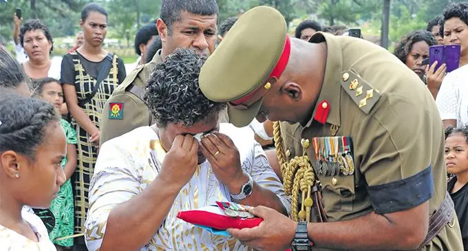 Deputy Commander Republic of Fiji Military Forces Brigadier-General Mohammed Aziz handing over the late WO2 Kolinio Mocevakaca’s medals to wife Diama Mocevakaca. Photo: RFMF Media Cell