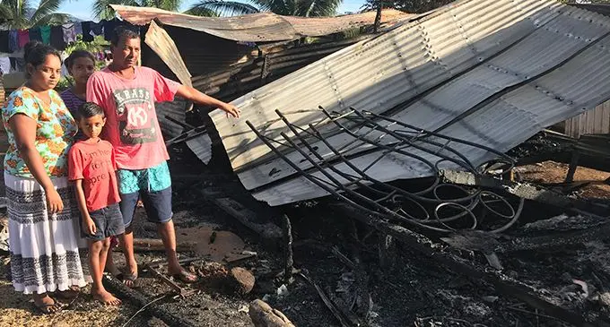 Jeetendra Prasad with his wife, Sanjeshni Lata, and children Arav Prasad and Vanshika Prasad pointing at the remains of their house in Mataniwai, Labasa, on May 24, 2019. Photo: Shratika Naidu