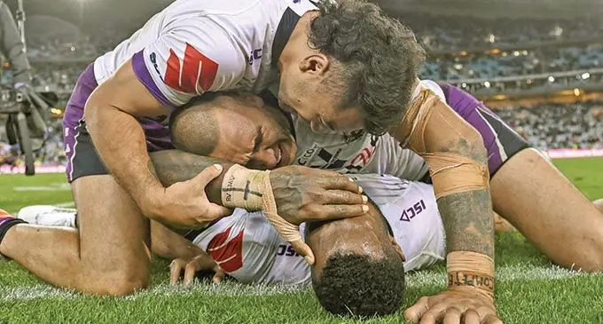 An emotional Vunivalu with his team-mates at the end of the grand final. Photos: Melbourne Storm