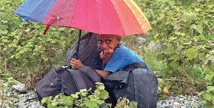 A student waits his turn to cross the raging river. Photo: JV Nadaubale / Facebook