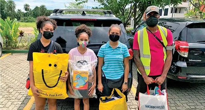 Families hand over relief items at the drive at McDonalds Fiji Nadi.