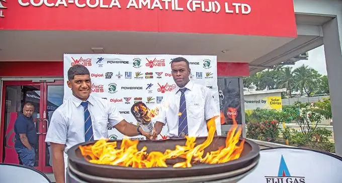 Ratu Kadavulevu School students George Naqau (left) and  Emoni Qaravanua lighting the Powerade torch of the Coca- Cola Games at Laucala Beach, Suva, on April 9, 2021. File Photo: Leon Lord  