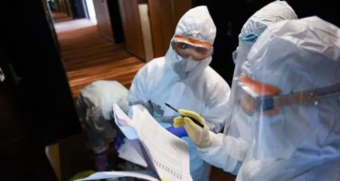 Staff members check the names of people involved in throat swab collection at a health observation point converted from a hotel at Longgang District of Shenzhen, south China's Guangdong Province, Feb. 27, 2020.  (Xinhua/Mao Siqian)