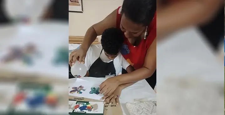 Mere Rasue helps a child during the art class at the Lautoka Coronation Methodist Church hall last week.