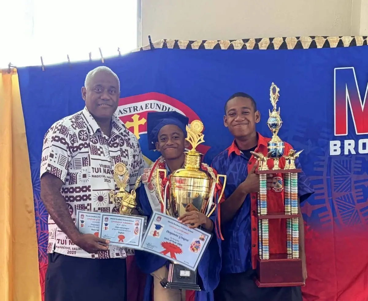 Joape Ginigini with sons Peni and Marika, holding their Dux cups for 2024 and 2025.