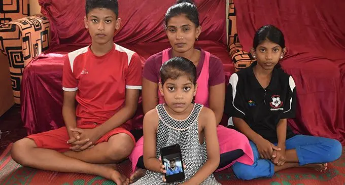 Back row, from left: Sahil Kumar, Renuka Devi, Shaniya Kumar. Front: Shaina Kumar holding a phone with their late father Sanjesh Kumar’s photo. Photo: Shalveen Kumar