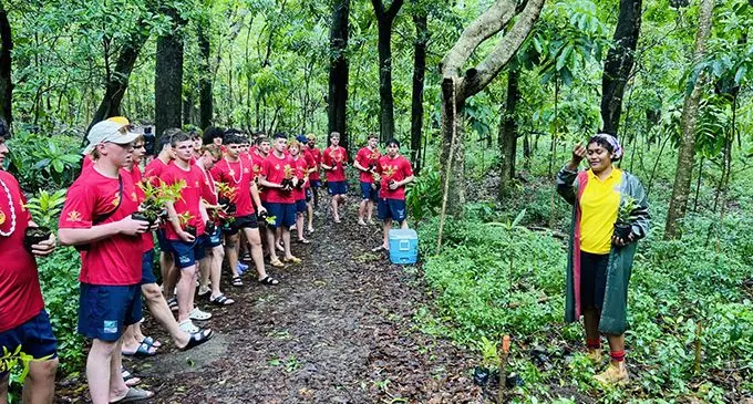 Students who were part of the Petero Sports Tours being briefed on the importance of trees before they start planting them in Sigatoka. Photo: Supplied  
