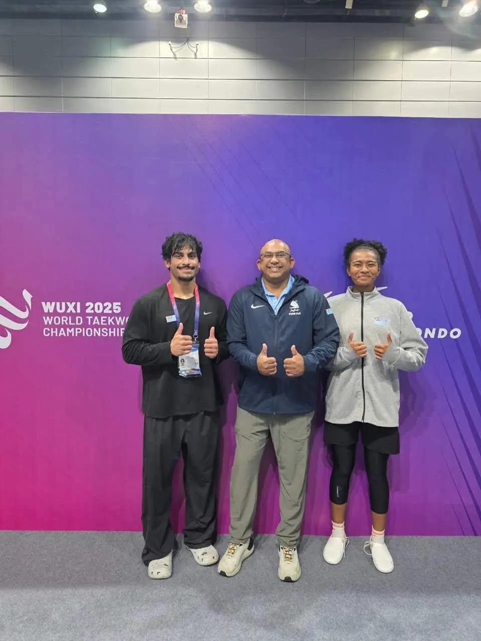 Taekwondo athletes, Lolohea Naitasi and Nipesh Prakash with head coach Neelu Nand at the 2025 World Taekwondo Championships in Wuxi, China.