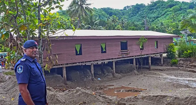A police officer looks at the damage caused  by the landslide. Photo: Department of Information 