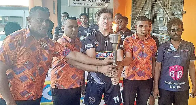 Ba players led by coach Imdad Ali (right) and Courts officials with the Courts IDC torch in Ba on October 3, 2022. Photo: Fiji FA Media