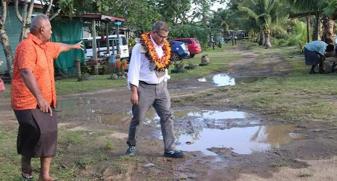 COP26 President Alok Sharma (wearing garland) got to see some of the impacts of climate change on Buretu Village in Tailevu. When he visited the village, Buretu Development Chair, Sunia Vosikata (wearing orange shirt)  showed Mr Sharma and his delegation some of the damage. Photo: Kelera Sovasiga-Tuisawa
