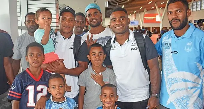 Fiji Airways Fijian 7s reps Napolioni Ratu (second from left)  and Seremaia Tuwai (fifth from left) with fans at the Nadi International Airport on November 28, 2019.  Photo: Waisea Nasokia