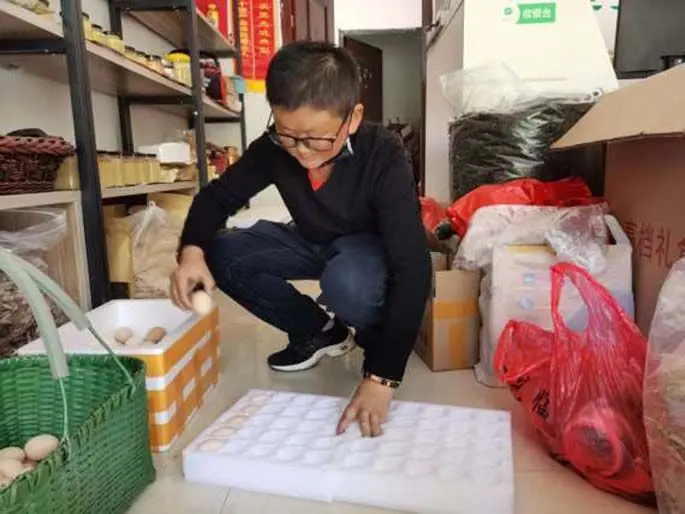 Zhang Chuanfeng packs his products in his store in the county of Jinzhai, east China's Anhui Province, April 20, 2020. (Xinhua/Chen Shangying)