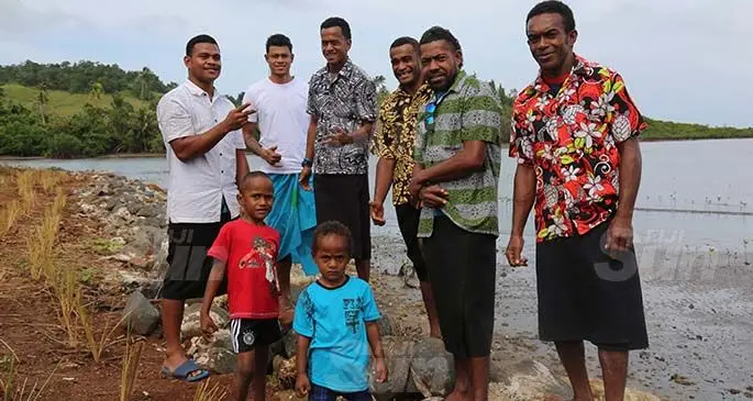 Youths of Viro Village at the new village’s seawall. Photo: Kelera Sovasiga