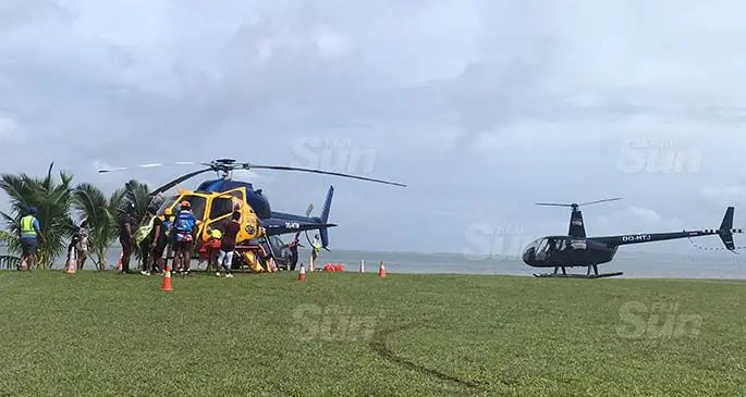 The LifeFlight Fiji team standing infront of the AS355 twin squirrel engine helicopter (left) while the The Robinson R44 comes in after taking a group on a 15 minutes scenic tour of Suva on June 6, 2020. Photo: Maraia Vula